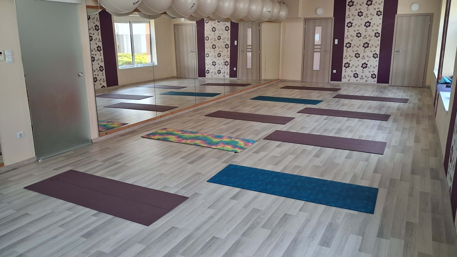 Kis csoportos Pilates óra — az oktató odahajol egyetlen vendéghez és korrigál